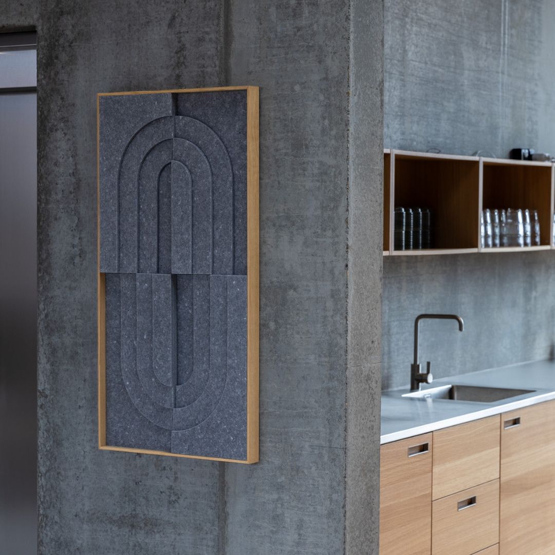 Gray felt soundproofing panel by Arturel with arched design, mounted on a concrete wall in a modern kitchen.